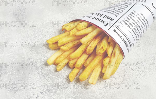 Fried French fries in a paper bag, on an abstract background, without people, in a rustic style, in a cone package, newspaper, a bag from the newspaper