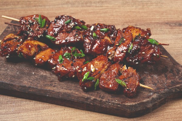 Yakitori chicken kebab, on skewers, with green onions and sesame seeds, top view, without people