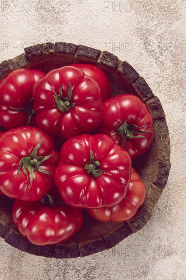 Pink tomatoes, in a rustic wooden bowl, close-up, no people