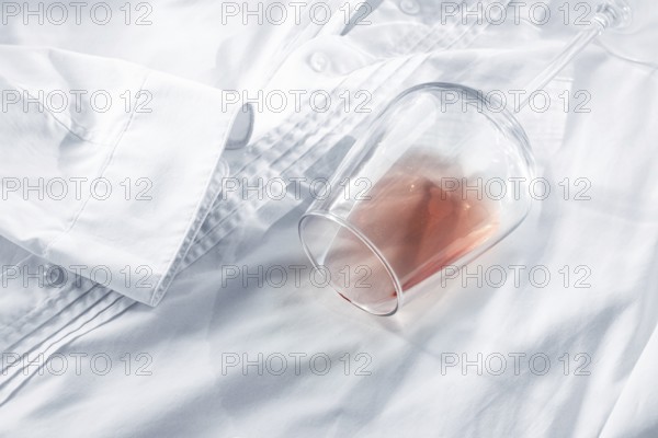 Glass, with pink wine, spilled on a white shirt, close-up, selective focus, no people, concept, top view