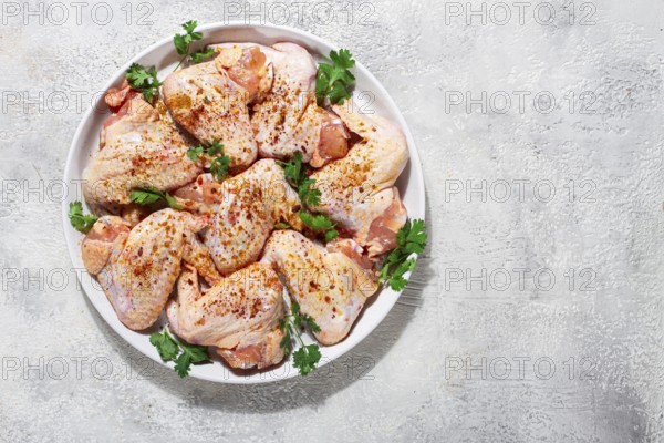 Marinated chicken wings prepared for grilling with spices and fresh herbs ready for cooking