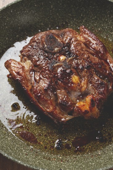 Fried steak, veal neck on the bone, cooking meat in a frying pan, top view, no people