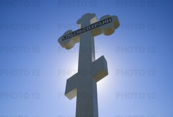 Orthodox cross against the blue sky and the sun. Krasnodar, Russia