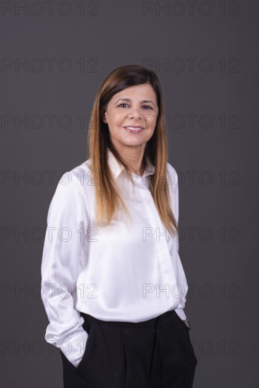 Elegant senior businesswoman smiling with her hands in her pockets
