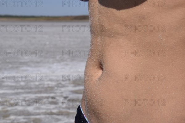 Salt on the girl's stomach. Taman, Krasnodar Krai, Russia