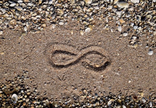 The sign of infinity on the sea. Coastal sand on the beach. Taman, Krasnodar Krai, Russia