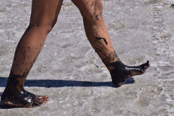 Legs walking girl on the dry bottom of a salt lake. Taman, Krasnodar Krai, Russia