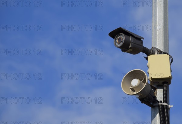 CCTV camera and loudspeaker alarm on a pole against a blue sky. Taman, Krasnodar Krai, Russia