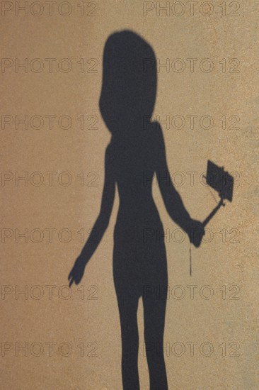 Shadow of a girl with a selfie stick on the beach. Golubitskaya, Russia