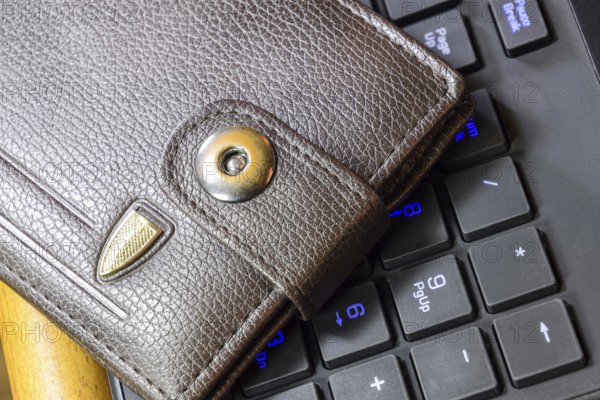Brown wallet lying on a black computer keyboard. Atyrau, Kazakhstan