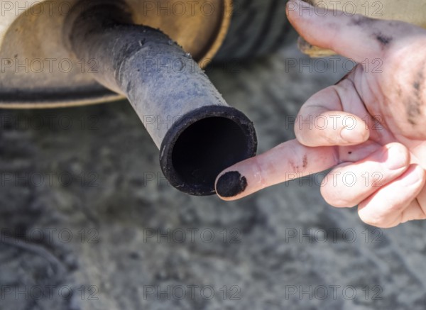 Soot from the exhaust pipe on the finger. Atyrau, Kazakhstan