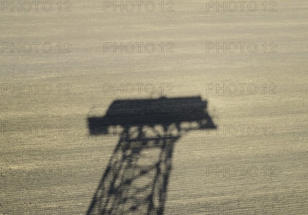 The shadow of a water tower on a plowed field. Atyrau, Kazakhstan