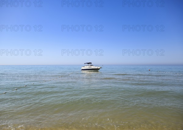 A small boat yacht in the sea near the shore. Taman, Krasnodar Krai, Russia