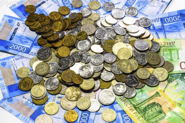 A handful of coins on new Russian banknotes in denominations of 2000 and 200 rubles. Krasnodar, Russia