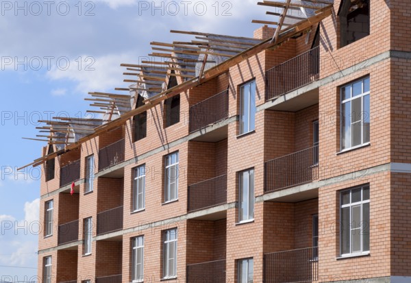A three-storey brick apartment building under construction. Atyrau, Kazakhstan