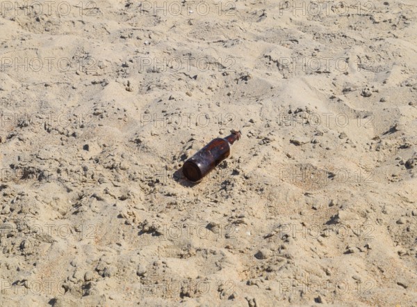 An empty bottle of beer is lying on the sand. Golubitskaya, Russia