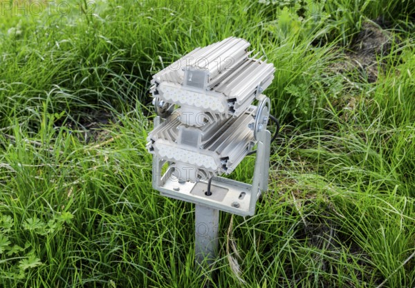 Streetlight illuminator is installed on the lawn. Atyrau, Kazakhstan