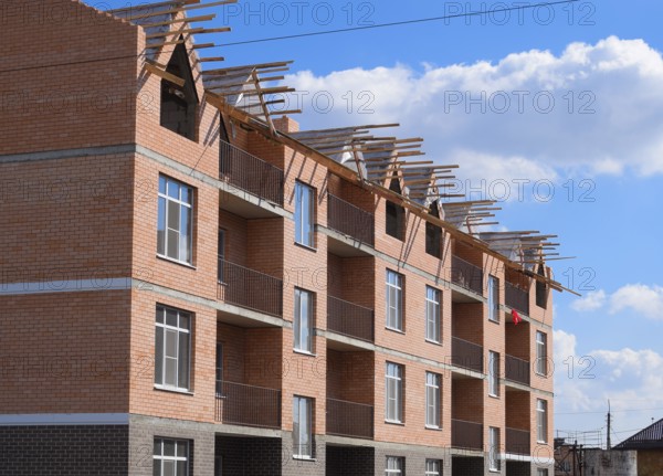 A three-storey brick apartment building under construction. Atyrau, Kazakhstan