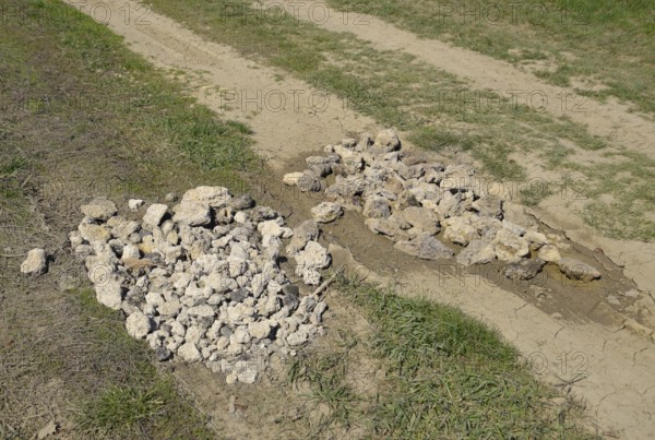 Road patching. Pits on the road are covered with stones. Atyrau, Kazakhstan