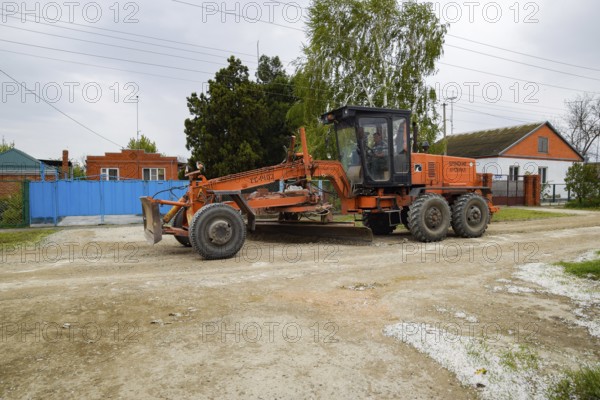 Grader on a dirt gravel road. Street repair by adding rubble. Krasnodar, Russia