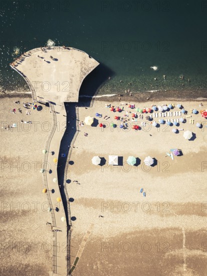 Batumi, Georgia - 15th august, 2025: Aerial top view of Batumi Georgia beach with pier bridge, colorful umbrellas, sunbathers and Black Sea coastline in summer