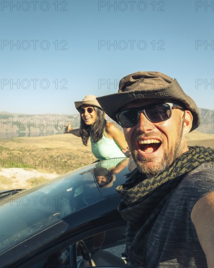 Happy travelers on summer road trip with rental car, symbolizing freedom, travel insurance, car hire lifestyle, and holiday adventure
