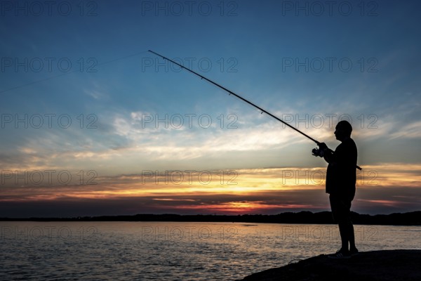 Silhouette Of A Fisherman With His Pole At The Atlantic Coast Of Wales, United Kingdom