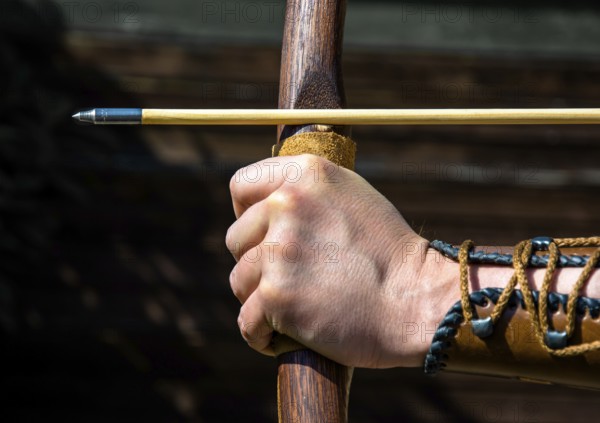 Hand Of An Archer Holds Bow And Arrow To Aim At Target, Austria