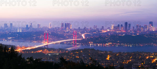 View from Camlica hill to 15 July Martyrs bridge with scyscrapers in the background after sunset.Romantic Istanbul.Turkey