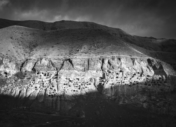 Black and white dramatic landscape of Vardzia, cave city. Georgia. Unique and mysterious places in caucasus