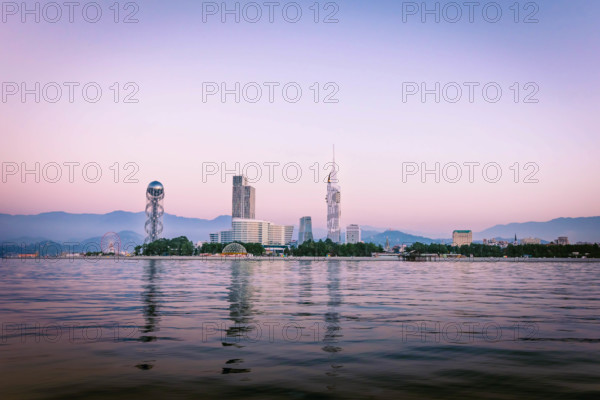 Iveria beach waterfront view with famous Batumi landmarks in the background: Chacha tower, Ferris wheel and alphabetic tower. Romantic holidays in Georgian vegas concept