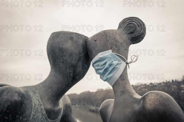 Statue of a couple with medical mask on. Concept of relationship and social distance during quarantine and pandemic of corona virus. Tbilisi.Georgia
