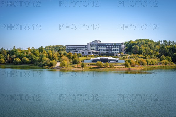 Organic lakeside hotel surrounded by trees under a clear blue sky, Zeulenrodaer Meer reservoir, Zeulenroda-Triebes, Thuringia, Germany