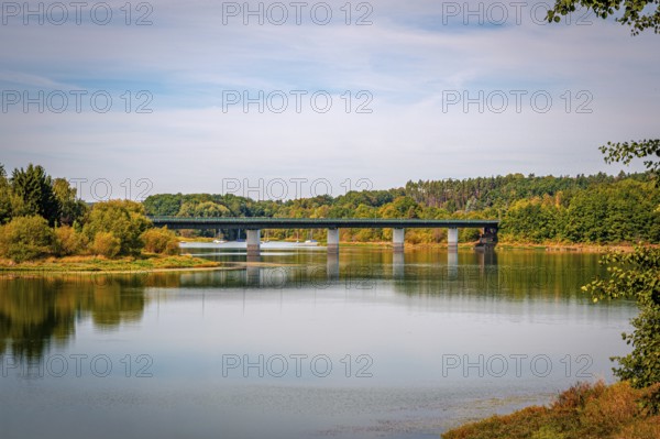 View of a bridge surrounded by green trees and a clear sky, Zeulenrodaer Meer reservoir, Zeulenroda-Triebes, Thuringia, Germany