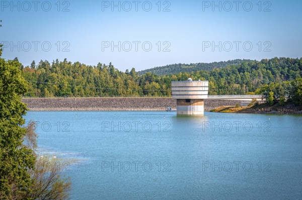 Round tower at the dam wall in the reservoir with surrounding forest and blue sky, Zeulenrodaer Meer reservoir, Zeulenroda-Triebes, Thuringia, Germany