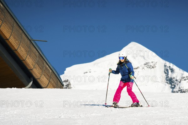 Young caucasian woman beginner skier on slope learn enjoy ski downhill in beautiful sunny day with Tetnuldi mountain peak background. Georgia ski holidays.Active sports. Recreational activity concept