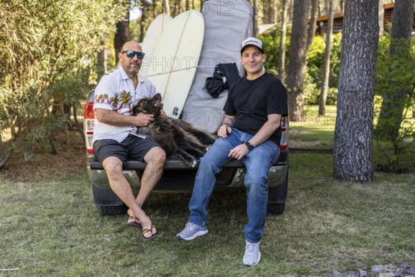 Friends and dog relaxing on a pickup truck