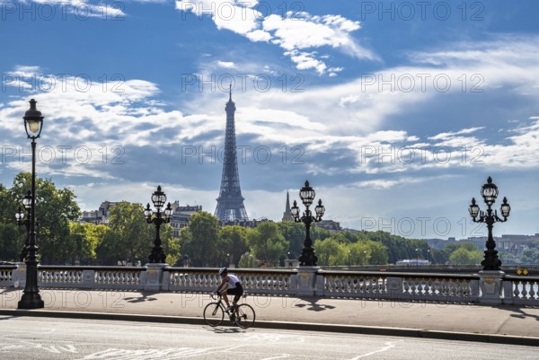 Bridge Pont Alexandre III Over River Seine With Single Bicycle Rider And View To Eiffel Tower In Paris, France