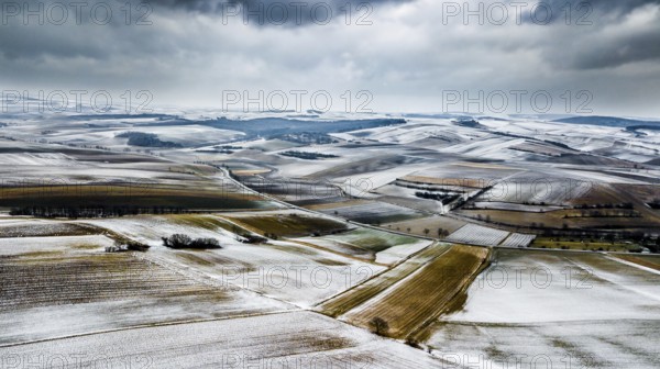 Aerial View Of Agricultural Winter Landscape With Remote Settlements And Snow Covered Fields In Austria