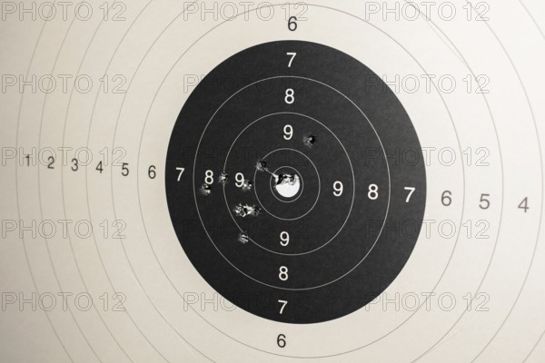 Hitmarks And Spot-On Hit On Round Paper Target With Bullet Holes From Shooting Training