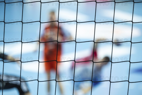 The net behind the goal and silhouette of handball players in the background. Lubin, Poland