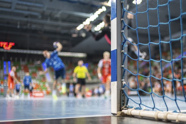 Detail of handball goal post with net and handball match in the background. handball match. Lubin, Poland