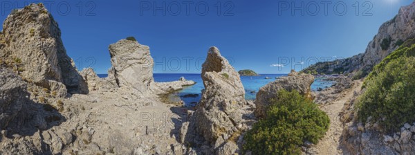 Rocky coastline with panoramic sea view at Grande Blue Beach with small island and clear sky above, Grande Blue Beach, Stegna, Archangelos, Rhodes Island, Greece