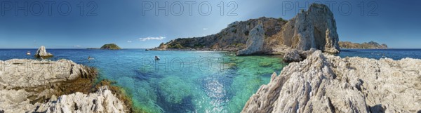 Panorama of the picturesque Grande Blue coastline with clear blue waters and the majestic cave of Archangelos under a bright blue sky, Grande Blue Beach, Stegna, Rhodes, Greece