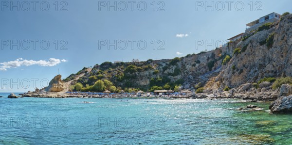 Grande Blue Beach with blue sea, rocky cliffs and a house under a clear sky, Grande Blue Beach, Stegna, Archangelos, Rhodes Island, Greece