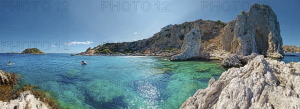 Picturesque Grande Blue coastal landscape with clear blue water and the majestic cave of Archangelos under a bright blue sky, Grande Blue Beach, Stegna, Archangelos, Rhodes, Greece