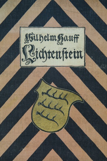 Book title, cover, book binding textile, novel, Lichtenstein by Wilhelm Hauff, publisher Abel und Müller, Leipzig, publisher dissolved in 1983, coat of arms of Württemberg, coat of arms of the ruler and state, script, letters, history of Baden-Württemberg, literature, studio, Germany