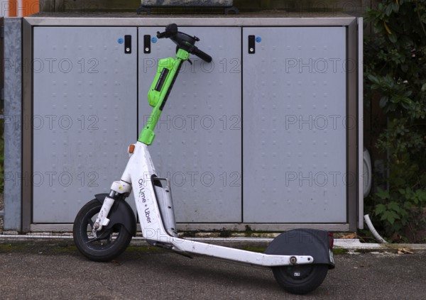 On the pavement, pavement, container for waste bins, parked e-scooter, electric scooter, scooter, in the bike rental of the company Lime, OnLime and Uber, Stuttgart, Baden-Württemberg, Germany