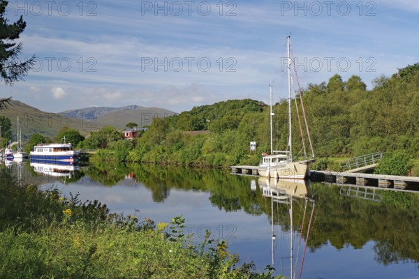 River landscape with boats and wooded hills in the background, Caledonian Canal, Fort William, Scotland, Great Britain