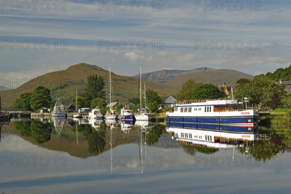 Harbour with boats and reflections under the surrounding green mountains, Caledonian Canal, Banavie, Fort William, Scotland, Great Britain